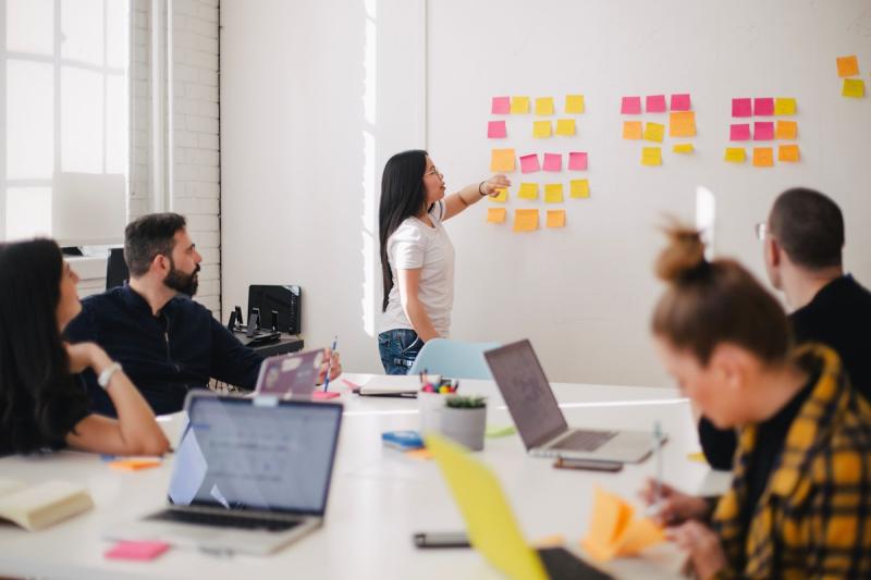 Two professionals brainstorming together at a whiteboard with creative ideas