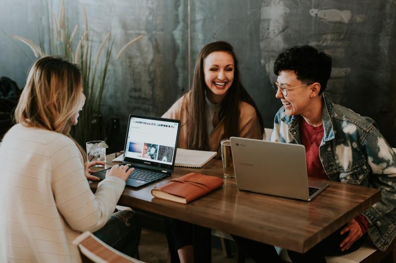 Professional working at a laptop in a modern workspace, building their side hustle alongside their day job