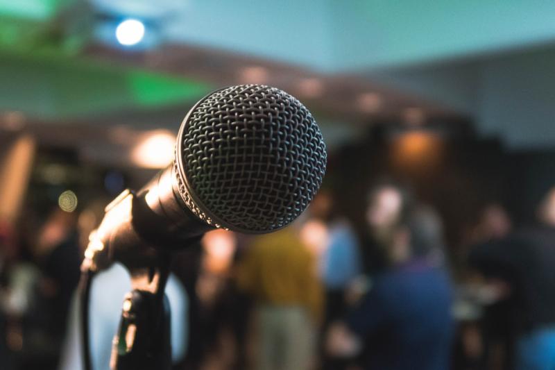 Empty stage with spotlight representing the pressure of being visible in professional settings